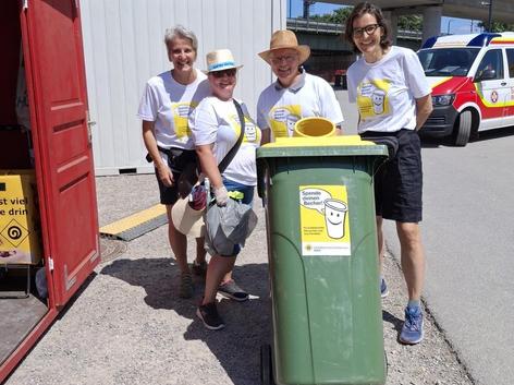 Ehrenamtliche Helfer:innen mit Spendentonne