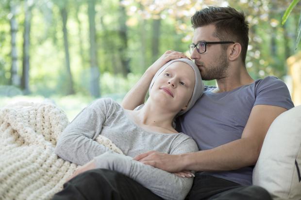 junges P&auml;rchen auf Couch, sie krebskrank, er umarmt sie