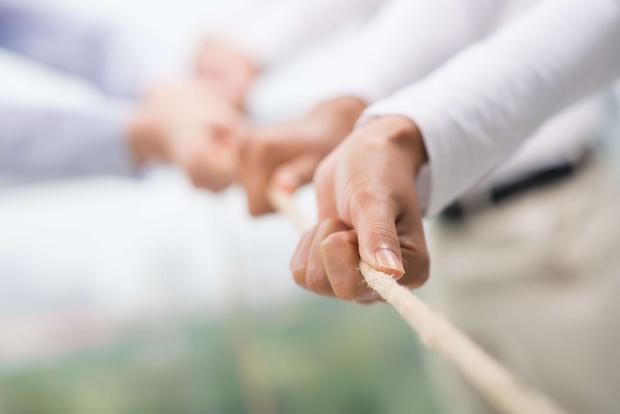 Hände halten gemeinsam ein Seil