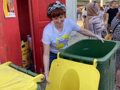 ehrenamtliche Mitarbeiterin beim Entleeren der Spendentonne