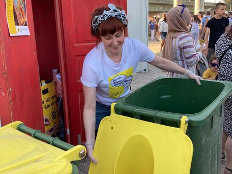 ehrenamtliche Mitarbeiterin beim Entleeren der Spendentonne 