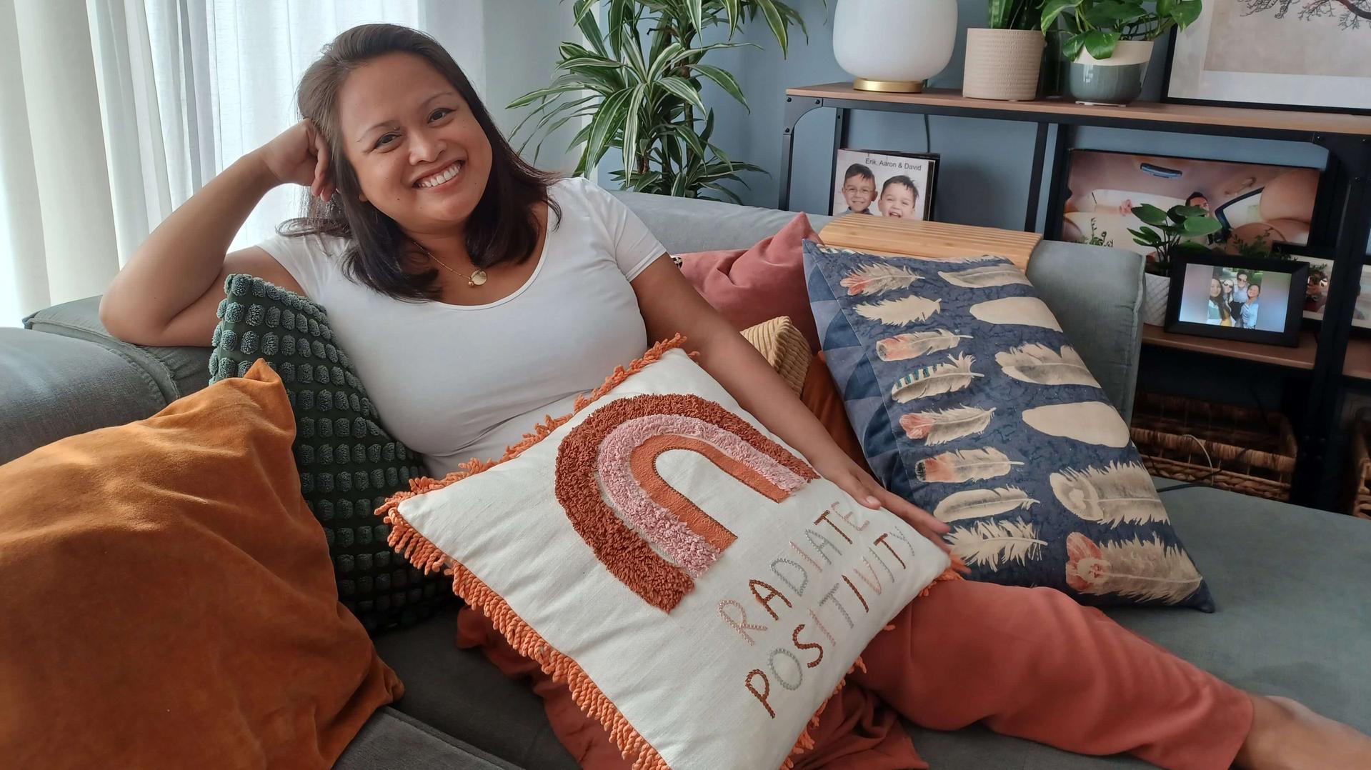 Laura l&auml;chelnd auf einem Sofa