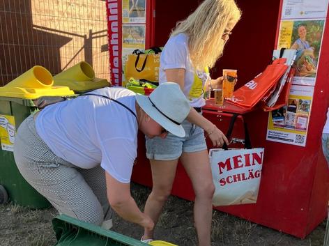 ehrenamtliche Mitarbeiterinnen mit Spendentonne vor der Spendenhütte