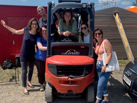 Mitarbeiterinnen der Krebshilfe Wien in und um einen Gabelstapler stehend