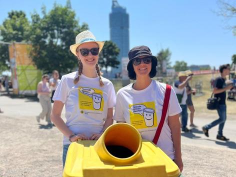 ehrenamtliche Mitarbeiterinnen mit der Spendentonne für die Becher
