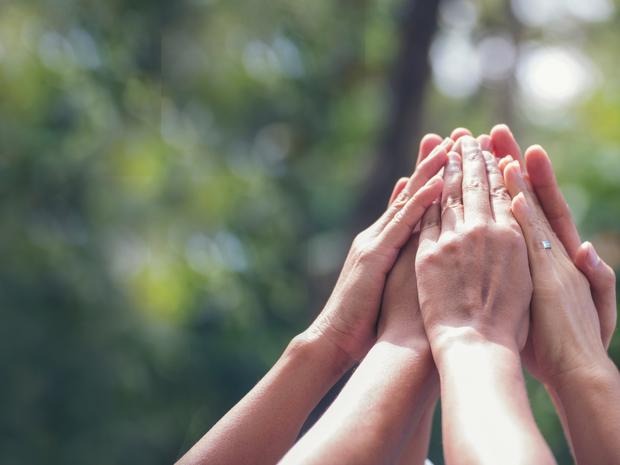 gefaltete Hände von mehrern Personen