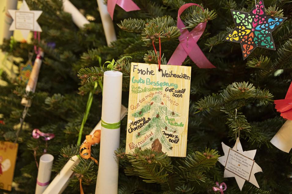 eine Grußkarte in Nahaufnahme hängt auf einem geschmückten Weihnachtsbaum